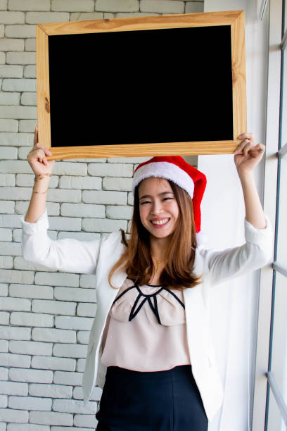 mulher que desgasta o chapéu para o natal ou a celebração do ano novo - placard holding celebration women - fotografias e filmes do acervo