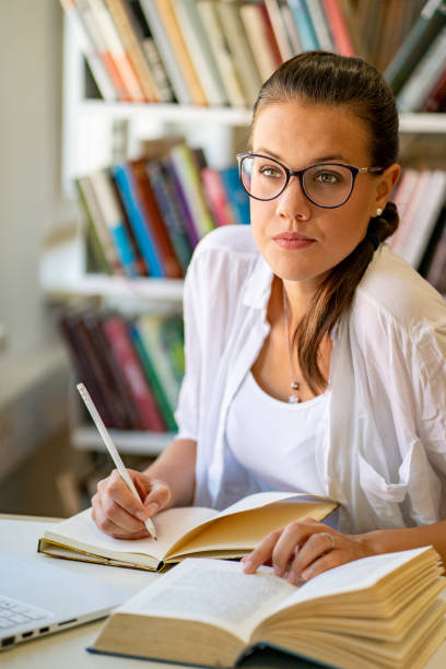 istock Young Woman Studying in Library - Stock Photo 1188651604