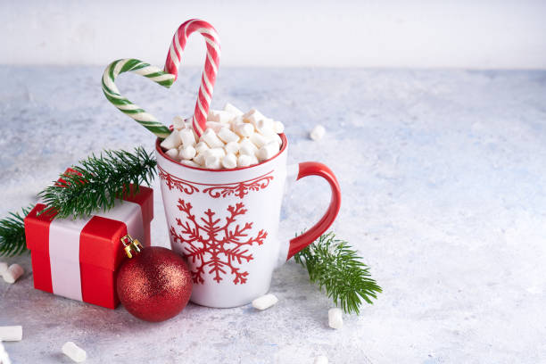 istock Christmas cup with sugar cocoa marshmallows and candy . Fir branches, christmas gift box on light background Copy space. 1188652772