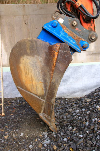 istock Excavator shovel digs into a gravel ground 1188659665