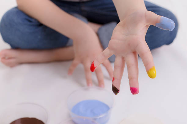 istock Kid drawing a face with brown paint in his tummy. 1188663290