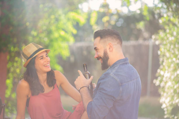 istock Young Spanish couple laughing, talking and drinking outdoors in a sunlit garden 1188671354