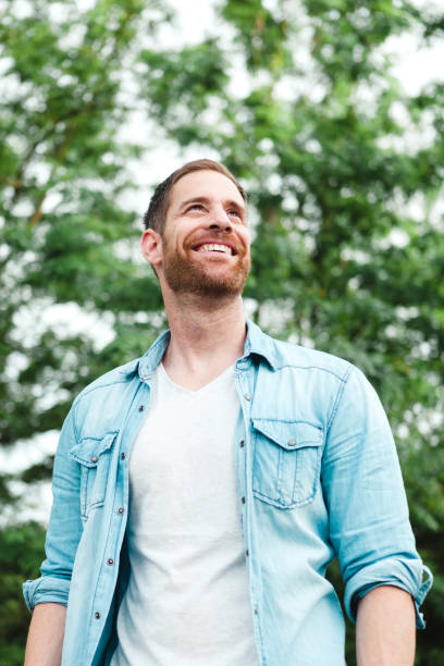 istock Casual guy with a denim shirt in a park 1188671434