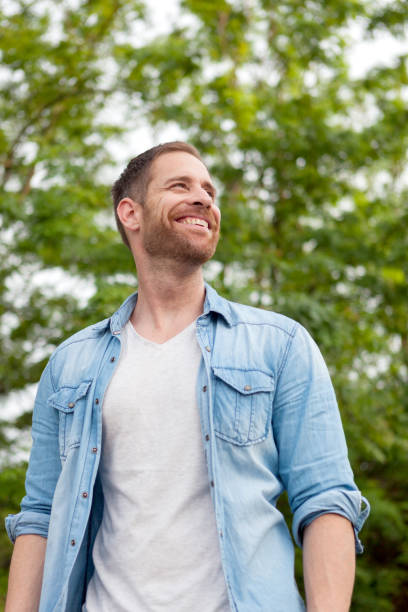 istock Casual guy with a denim shirt in a park 1188671443