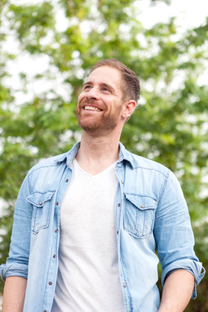 istock Casual guy with a denim shirt in a park 1188671456