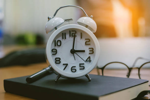 istock retro clock time at 9 o'clock with notebook or memo on wood table, times of memory writing diary concept vintage color tone. 1188671677