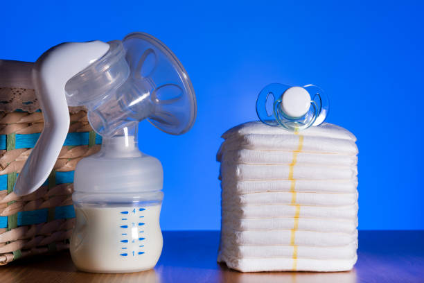 istock Breast pump stands among nipples and diapers 1188673359