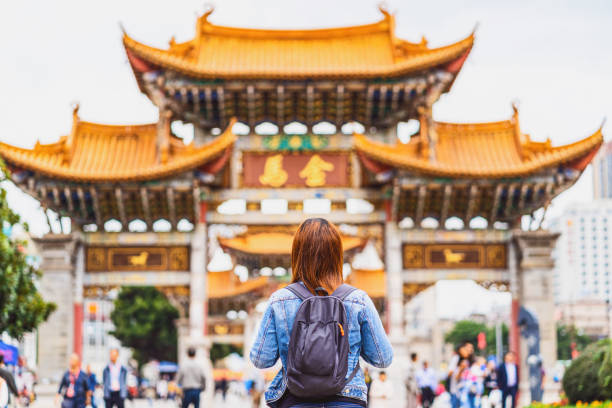 asian woman looking and sightseeing when travelling over the Jinbi square, Kunming, China stock photo