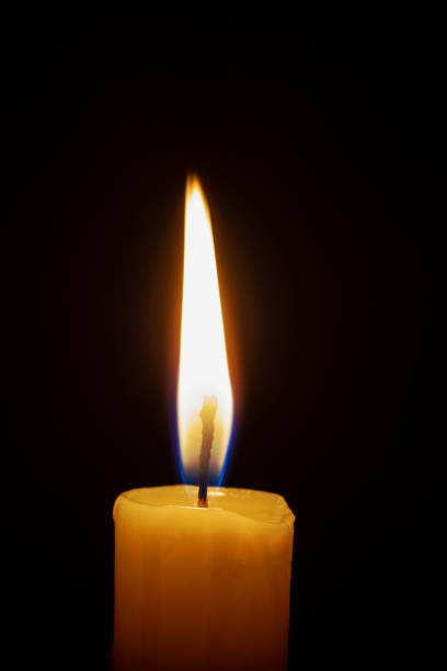 istock a lonely burning candle in the darkness 1188678429