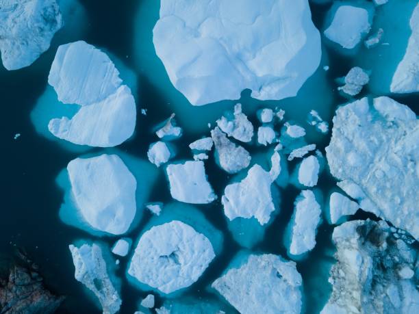 istock Icebergs drone aerial image top view - Climate Change and Global Warming. Icebergs from melting glacier in icefjord in Ilulissat, Greenland. Arctic nature ice landscape in Unesco World Heritage Site. 1188680062