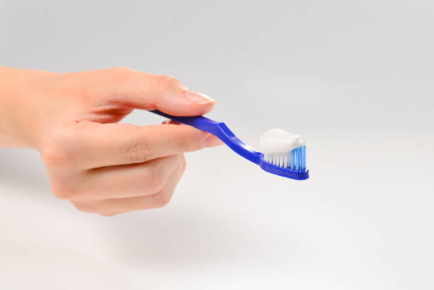 istock Woman holds toothbrush with toothpaste in her hand isolated on white background. 1188680082