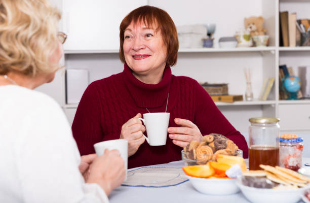 istock Smiling elderly woman drinking tea with female friend 1188680272