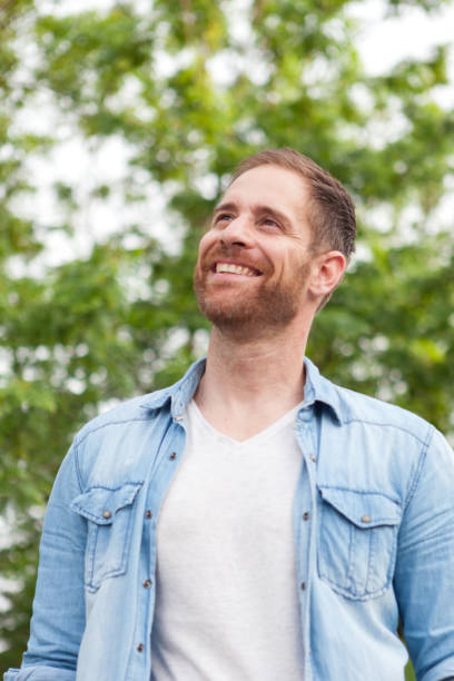 istock Casual guy with a denim shirt in a park 1188684305