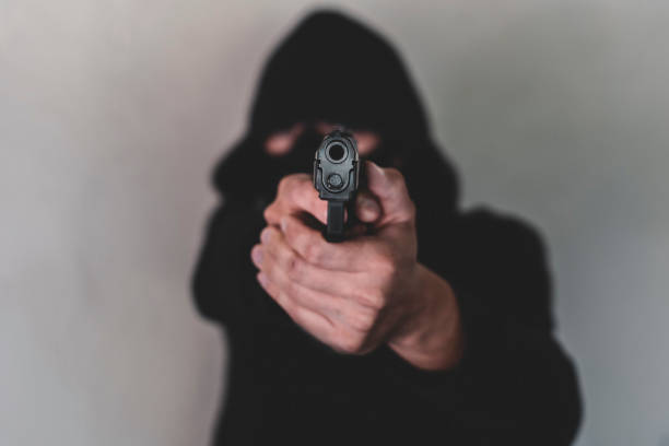 istock A man pointing a gun at lens 1188685002