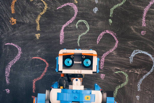 lego boost vernie le robot debout contre le tableau noir avec des points d'interrogation colorés - toy figurine plastic editorial photos et images de collection