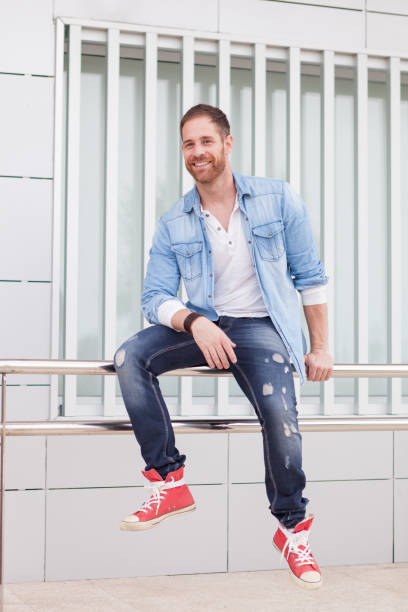 istock Casual guy sitting on a railing in the street 1188689305