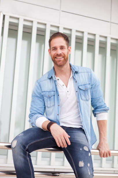 istock Casual guy sitting on a railing in the street 1188689366
