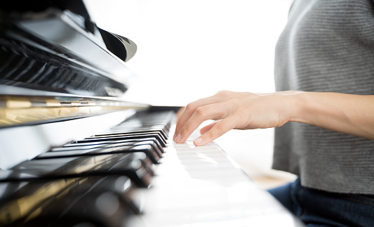 Closed up hands of woman playing piano