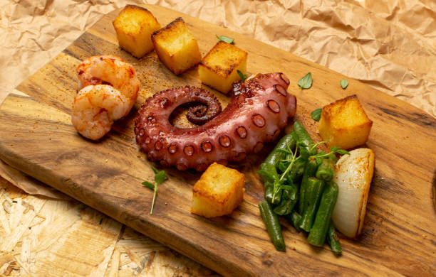 istock Grilled octopus tentacle on a wooden cut board served with shrimps 1188694236