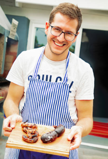 istock Millennial Argentinian cook presenting roasted morcilla and chinchullins 1188694308