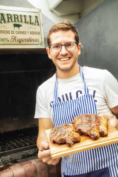 istock Millennial Argentinian cook presenting roasted rib eye and strip steaks 1188694833