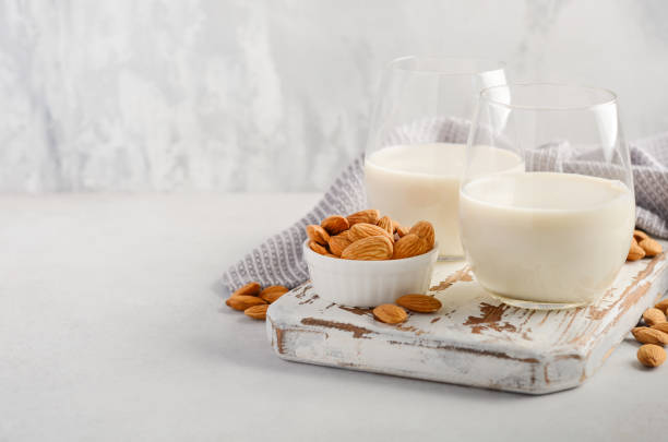 Almond milk and almonds on a white wooden cutting board. Almond milk and almonds on a white wooden cutting board, selective focus. Whole Milk stock pictures, royalty-free photos & images