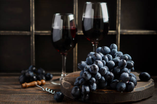 istock Fresh Black Grapes and Red Wine on Wooden Table 1188697150
