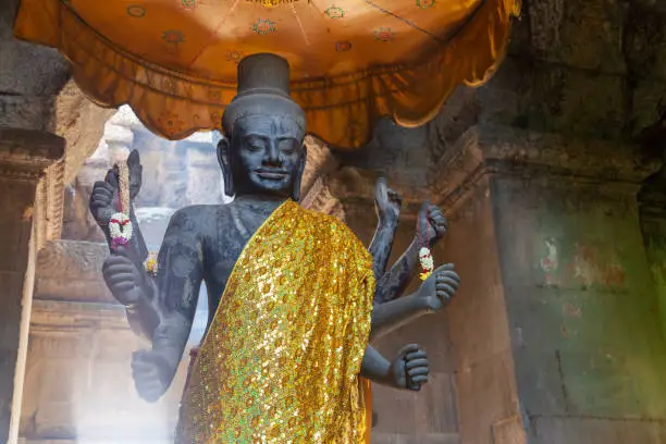 Photo of Statue of Vishnu at Angkor Wat. Standing in a nice spot which is lit from behind by the sun shining through a opeing in the ceiling.