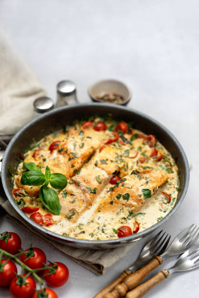 istock Delicious tuscan cream salmon with spinach in a black pan 1188698962