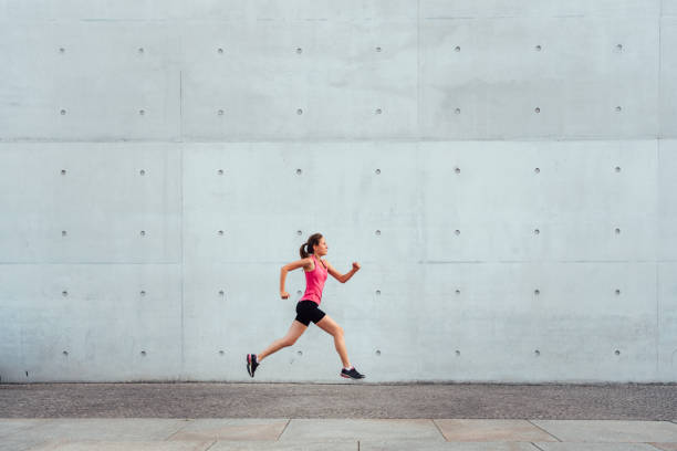 istock young sportswoman running in front of concrete wall 1188699537