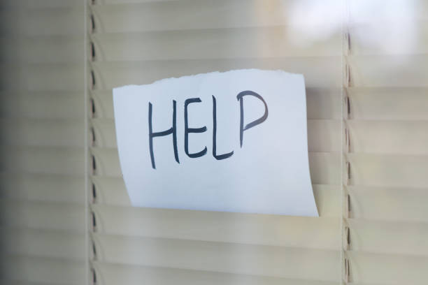 istock showing through the blinds a call for help written on a piece of paper 1188701106