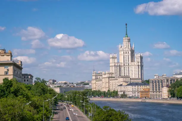 Moscow view with Kotelnicheskaya high rise building and Moscow river on sunny summer day. Blue sky and white clouds.