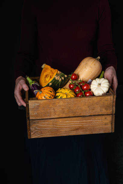 istock female hands holding wooden box with vegetables assortment 1188702884