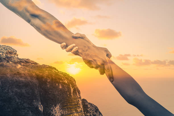 istock People helping each other up a mountain cliff. 1188704439