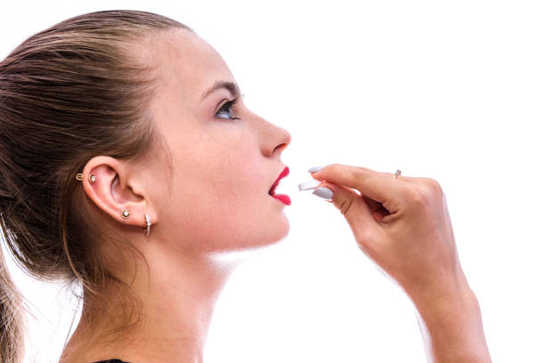 Woman taking pill isolated on white. Dieting concept