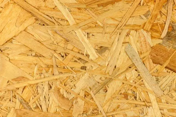 Building material. OSB boards are made of brown wood chips sanded into a wooden background. Background from wood fiber board.