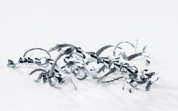 A bunch of aluminum chips on a white background. A bunch of aluminum chips on a white background. Selective focus. aluminum shavings stock pictures, royalty-free photos & images