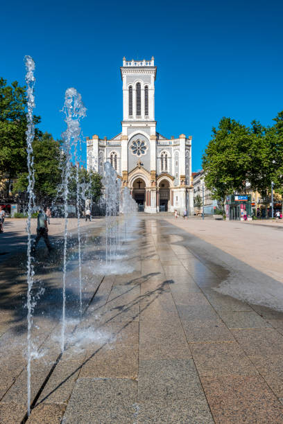 The square of Jean Jaures in Saint Etienne downtown with fountains. Morini Andre catholic church is at background. Saint-Etienne, France - July 29, 2019 The square of Jean Jaures in Saint Etienne downtown with fountains. Morini Andre catholic church is at background. saint étienne photos stock pictures, royalty-free photos & images