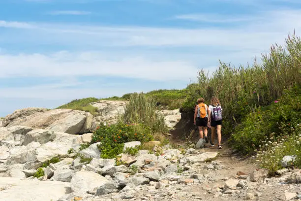 Photo of Two hikers on a cliff trail