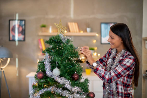 istock Beautiful woman decorating Christmas tree at home. 1188720523