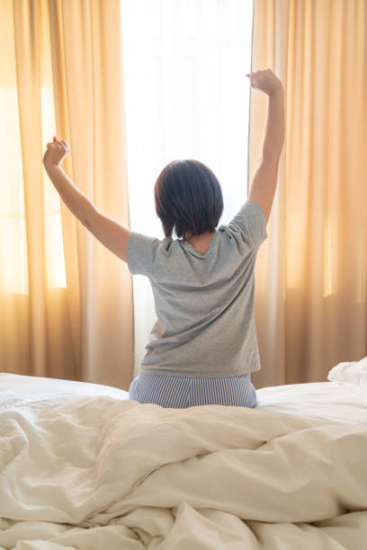 istock Woman stretching in bed after wake up, back view 1188720840