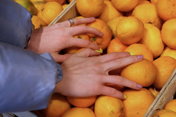 istock women's hands take tangerines from the box in the store 1188722961