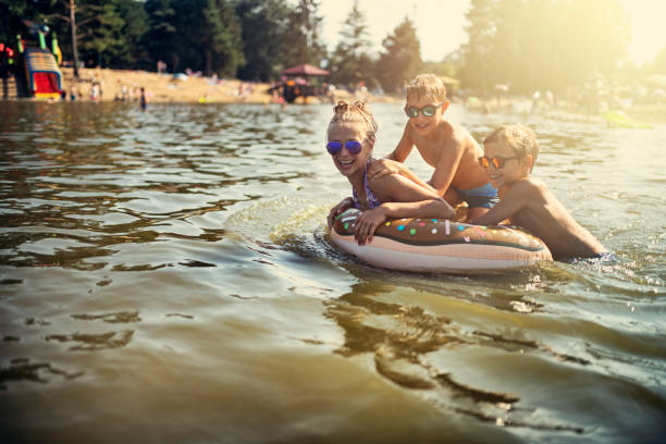 niños disfrutando jugando en el lago - child inflatable raft lake family fotografías e imágenes de stock