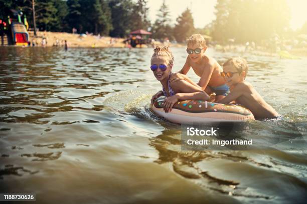 Kids Enjoying Playing In Lake Stock Photo - Download Image Now - Lake, Swimming, Child