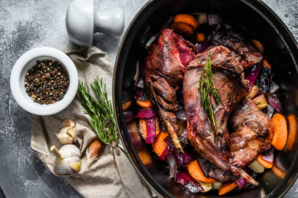 Roasted Rabbit Haunches in stewpot with Stewed Vegetables. Cooking stew. Top view Roasted Rabbit Haunches in stewpot with Stewed Vegetables. Cooking stew. Top view. rabbit game meat stock pictures, royalty-free photos & images