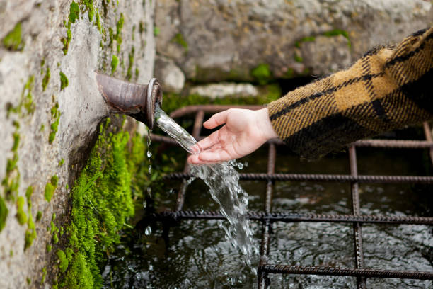 istock Hand touching water from a natural fountain 1188735457