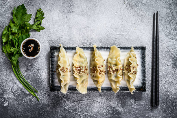 istock Steam Korean dumplings on a ceramic plate. Gray background. Top view. Space for text. 1188737829