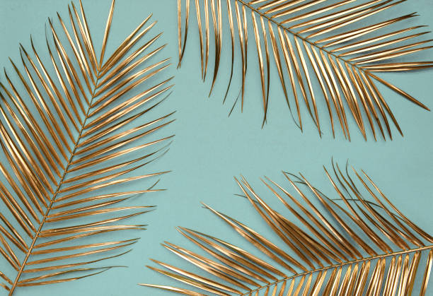 istock Gold painted date palm leaves on desaturated turquoise background 1188744227