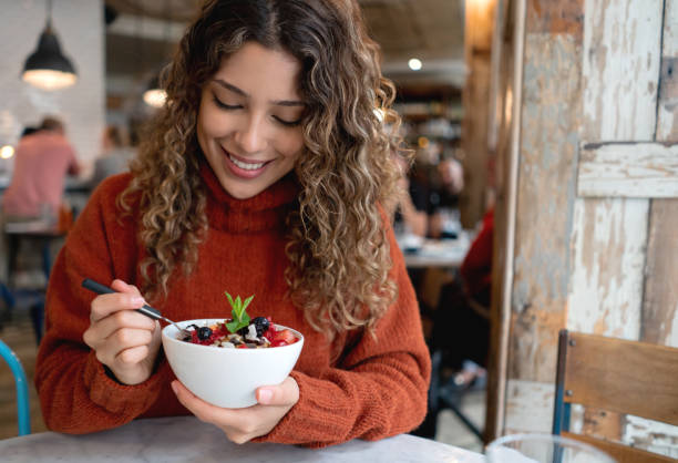 istock Woman at a restaurant eating a parfait for breakfast 1188746053