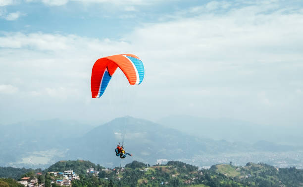 istock Paragliding with instructor using colorful paraglider over Pokhara town, Nepal. Active vacation concept image. 1188754860